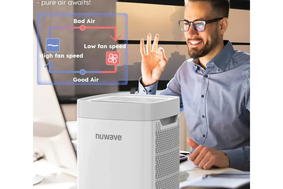 A man working with NuWave portable air purifier on his desk