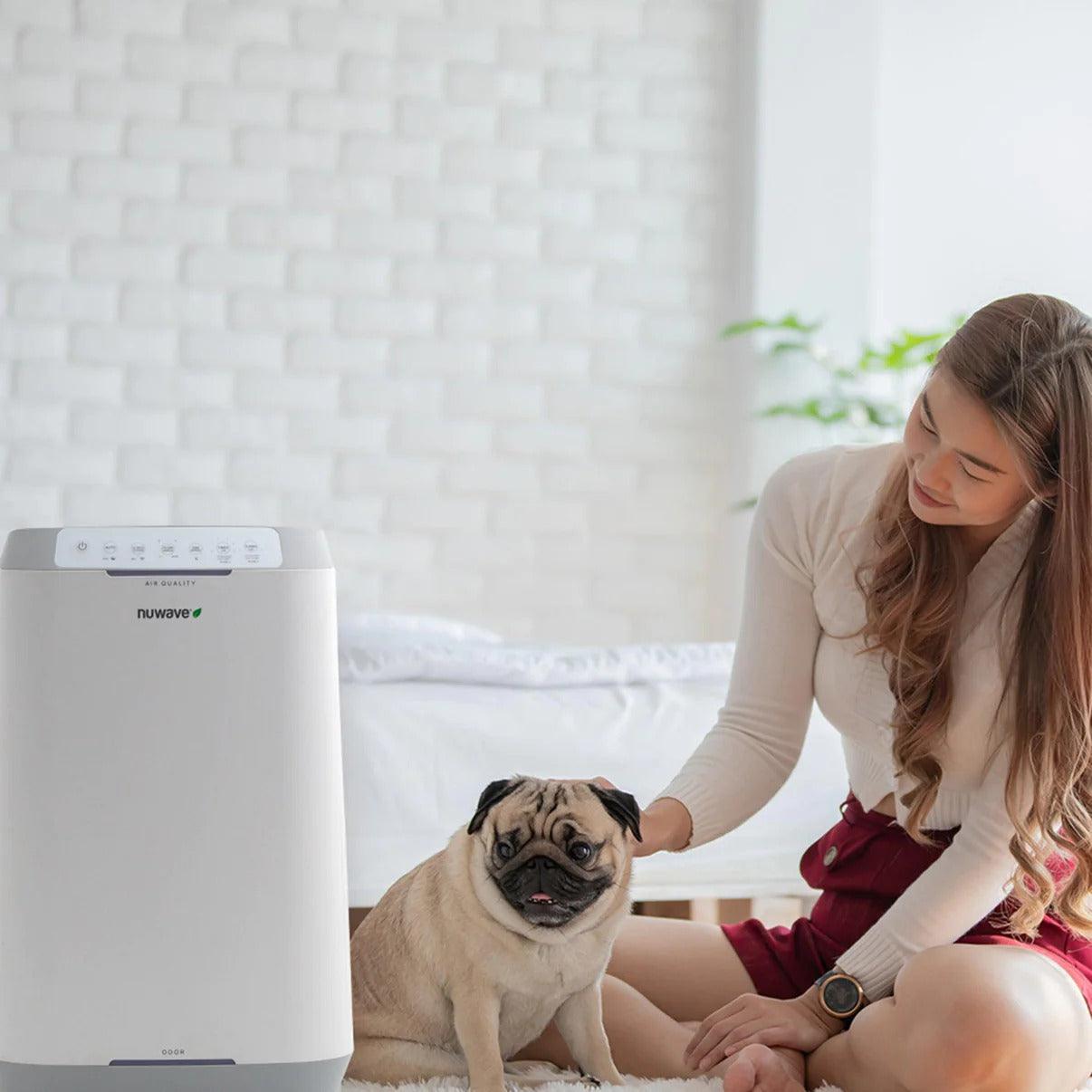 A woman and her dog enjoying clean and fresh air with the NuWave OxyPure Zero Air Purifier.