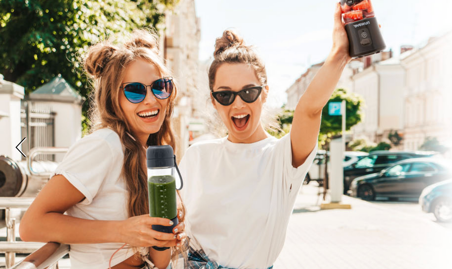 Two girls happily smiling while using the Nuwave On-The-Go Portable Blender